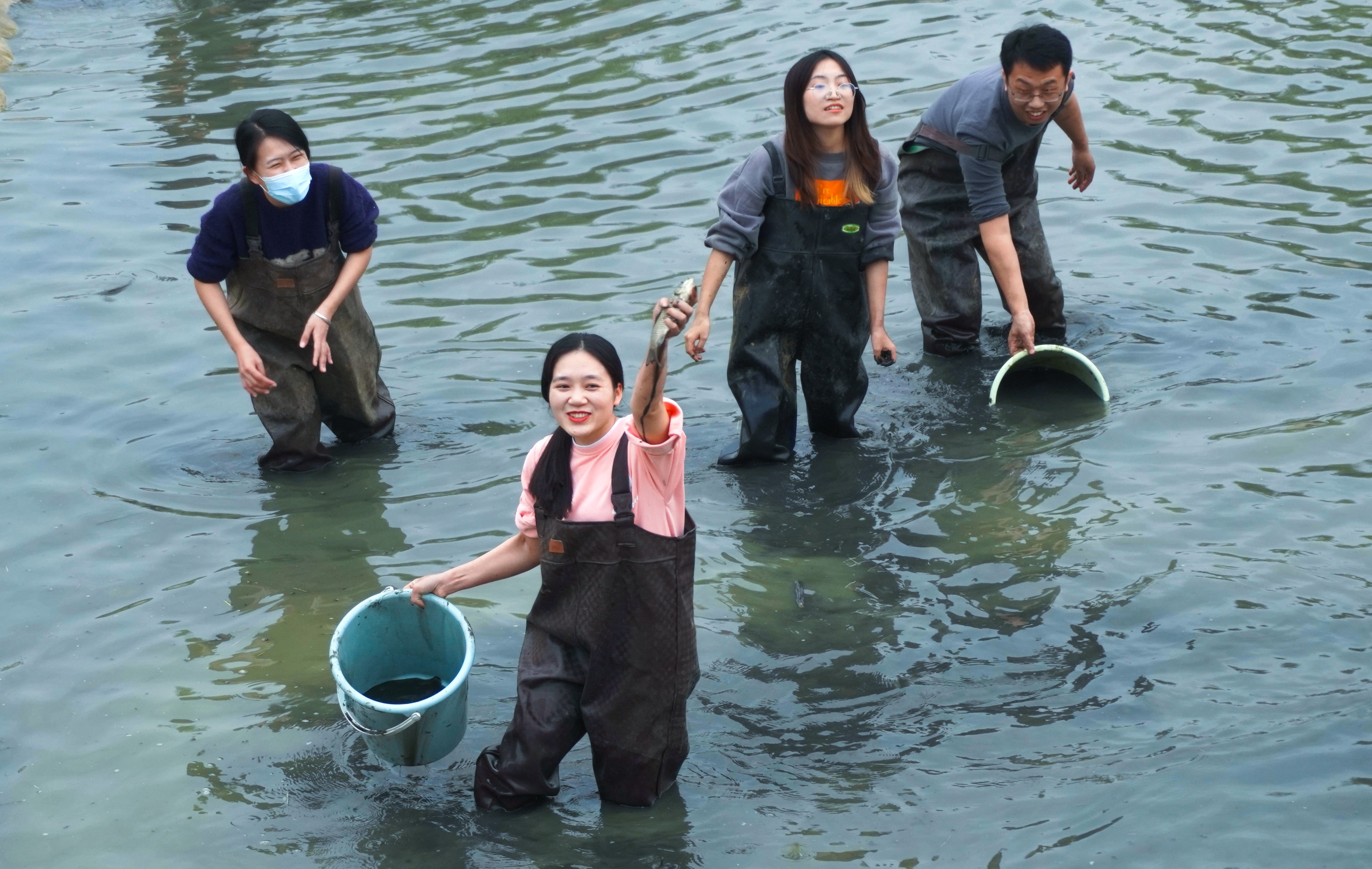 学生在浑水中摸到鱼时的欢快(yl6809永利官网记者 徐震 摄)